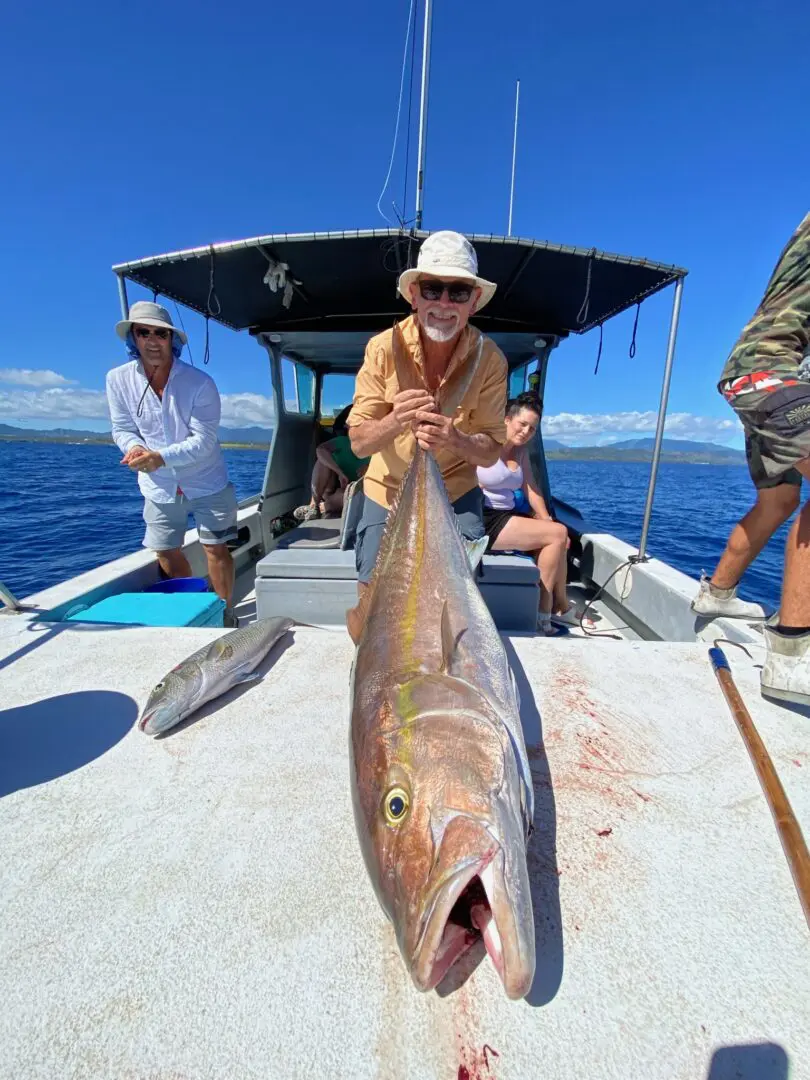 A man holding a fish on the boat