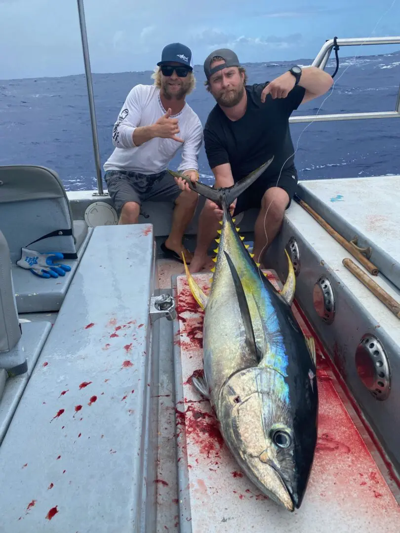A couple of people on a boat with a fish.