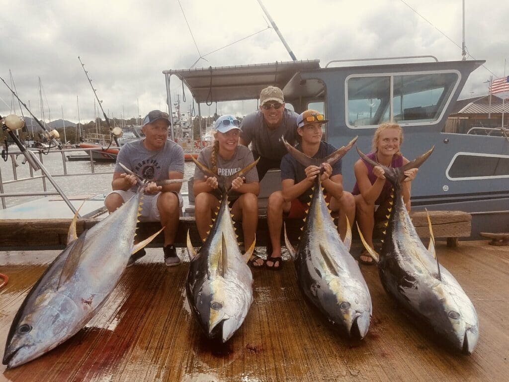 Five people with large caught fish.