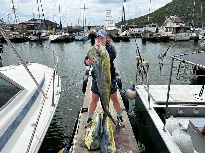 A man holding a fish on the dock