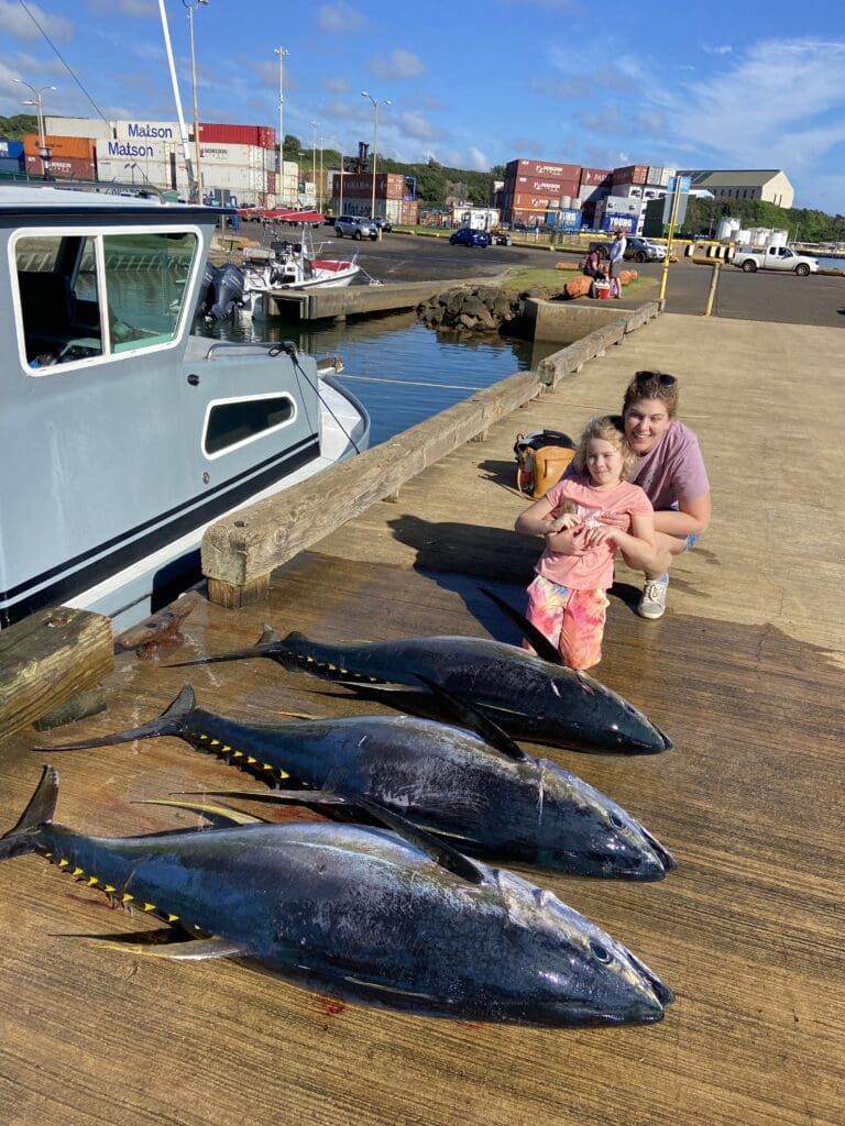 Woman and child with large caught fish.