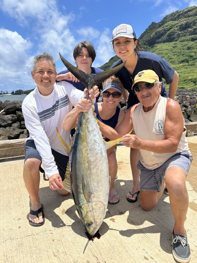 A group of people standing around a large fish.