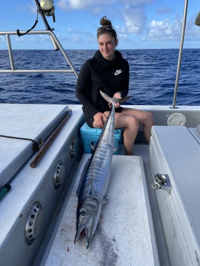 Person holding large fish on a boat.