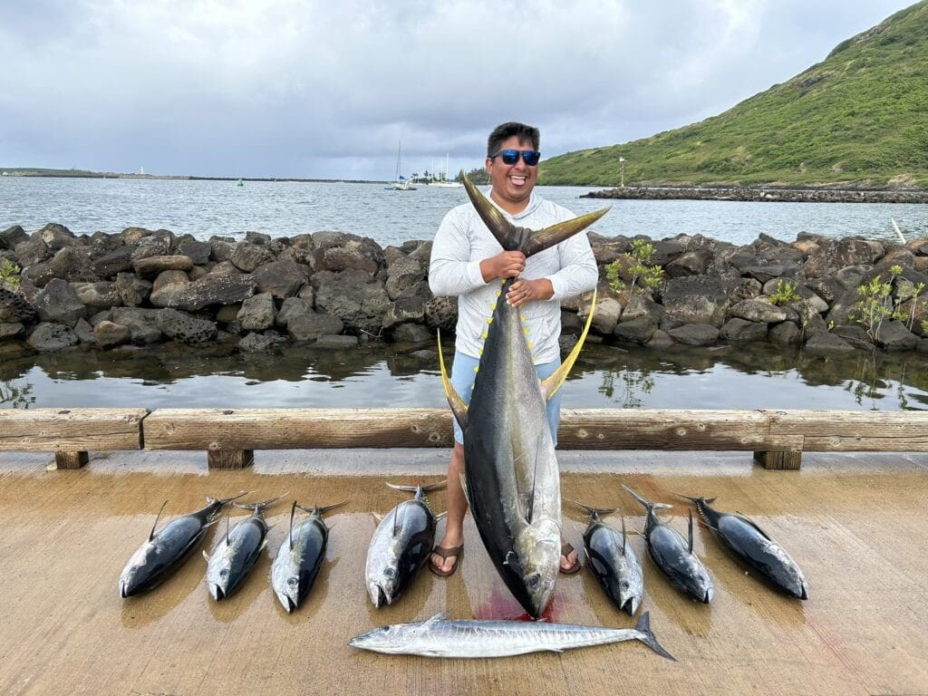 Man holding large fish by the shore.
