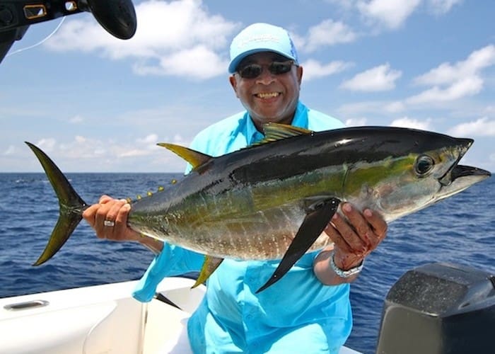 Man holding a large fish on boat.