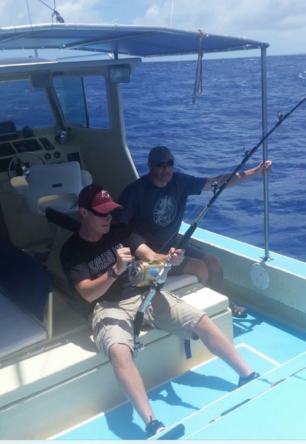 Two men fishing on a boat.